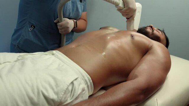 Laser machine hair removal procedure at spa wellness center hotel to a latin muscle model handsome in chest torso