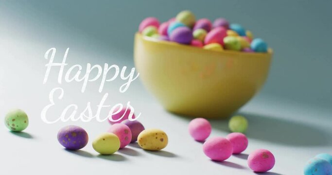 Animation of happy easter text over colourful easter eggs in bowl on blue background