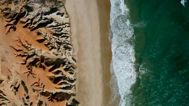 Aerial view of the sea, waves and the cliffs of Morro Branco, Ceara, Brazil
