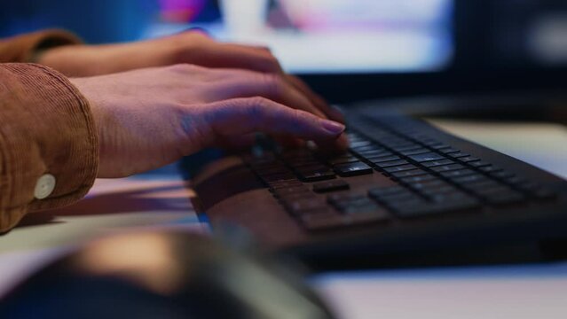 Focus on computer peripheral used by IT admin to type lines of code on desktop PC in apartment. Close up shot of keyboard used by software engineer programming at home, camera A