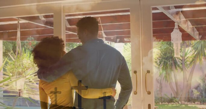 Animation of spots of light over happy diverse couple embracing at home