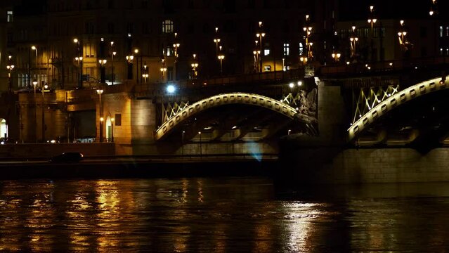 Budapest city (Hungary capital) center view with Margit Bridge and Danube river at night, light reflections, distant panoramic shot