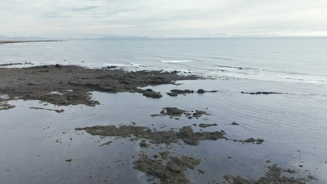 Aerial view of  calm ocean, slow waves, cloudy day at Ytri Tunga, Snaefellsnes.