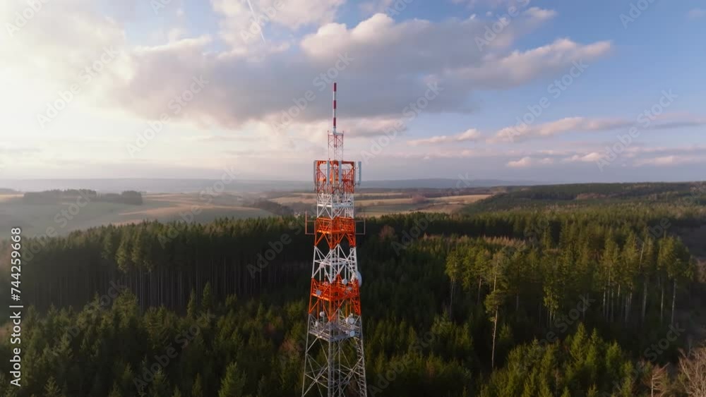 Poster parallax drone view of tower standing tall in between a forest during afternoon. aerial shot.