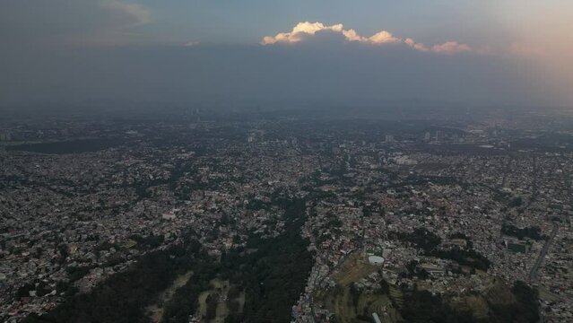 Aerial footage of the cityscape of Indore with a cloudy dusk sky in the background at sunset, India
