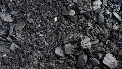 Natural fire ashes with dark grey black coals texture. It is a flammable black hard rock. Space for text.