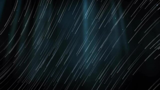 Animation of streaming white light trails over spotlights on dark background