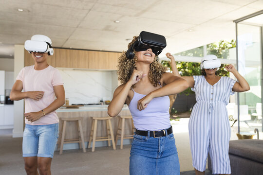 Diverse friends enjoy virtual reality games at home