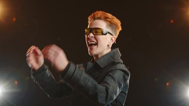 An enthusiastic lesbian woman engages in a passionate dance, clad in her denim jacket, under the vibrant beams of a spotlight, symbolizing the celebration of her pride and freedom. Camera 8K RAW. 