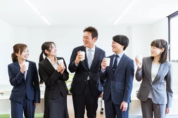 Fotobehang コーヒーを飲みながら充実した笑顔で談笑するビジネスマンとビジネスウーマン（アジア人・日本人の男女）  © buritora
