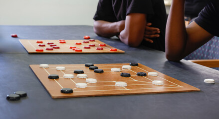 african american men with two boards playing, Nine men's morris strategy board game