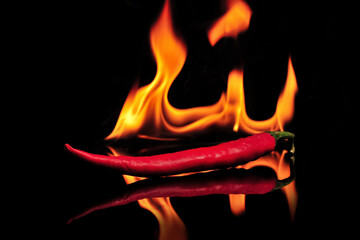 Red chilies burning in flames on a black glass table