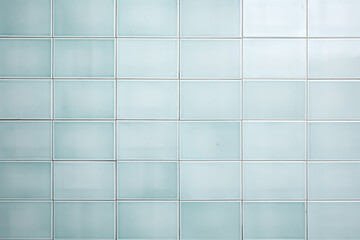A close up of a bathroom wall with light blue azure rectangle tiles