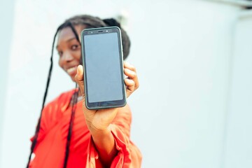 black young teenage girl holding mobile phone display at camera 