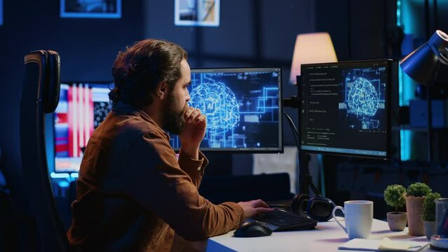 Software developer writes code on multimonitor setup PC to visualize artificial intelligence neural networks. Teleworking IT employee runs AI script on computer from home office, camera A