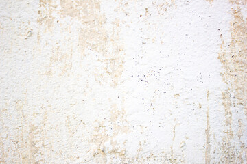 Surface of an old, dilapidated plastered wall is peeling plaster.