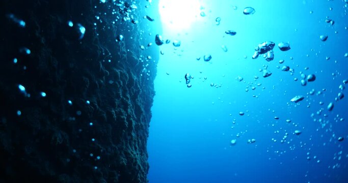 air bubbles slow  underwater coming up scenery dark blue and sun shine ocean scenery from scuba  divers backgrounds