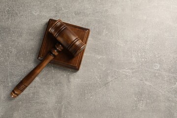 Wooden gavel on grey textured table, top view. Space for text