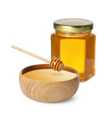 Natural honey dripping from dipper into wooden bowl. Jar full of honey on white background