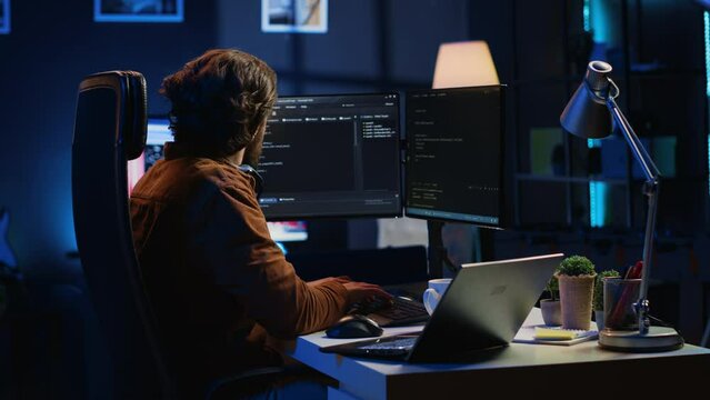 Software programmer taking break from coding, putting headphones on and stretching on desk chair during remote job shift. IT professional pausing tasks, listening music, loosening up, camera A
