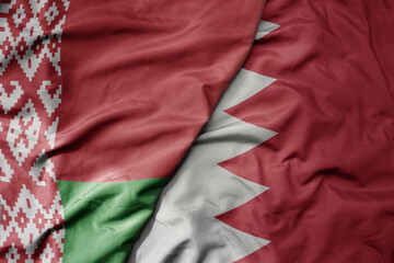 big waving national colorful flag of bahrain and national flag of belarus.