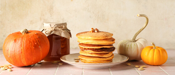 Composition with tasty pumpkin pancakes and honey on table
