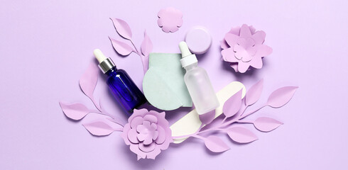 Obraz na płótnie Canvas Natural cosmetic products with paper decor on lilac background