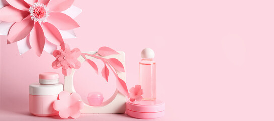 Obraz na płótnie Canvas Natural cosmetic products with paper flowers on pink background with space for text