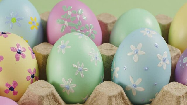 Closeup view of multi-colored Easter eggs contained inside an egg carton. Slow motion. Beautiful seamless border with easter eggs. Easter Sunday is a religious Christian holiday