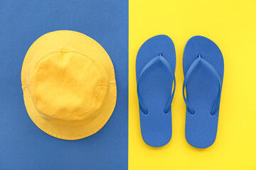 Pair of blue flip flops and panama on colorful background