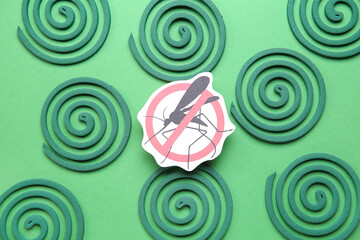 Fototapeta na wymiar Mosquito spirals and anti insect sign on green background