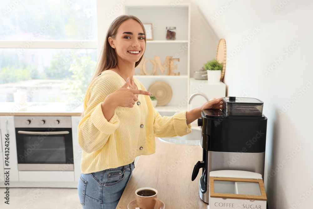 Canvas Prints beautiful young woman pointing at coffee machine in kitchen