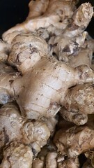 Close up pile of tasty fresh ginger sold at the market as a background.