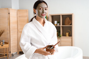 Young woman with facial mask in bathroom