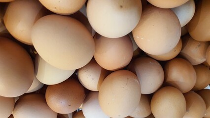 Close up of  randomly stacked chicken eggs sold at the market as a background.