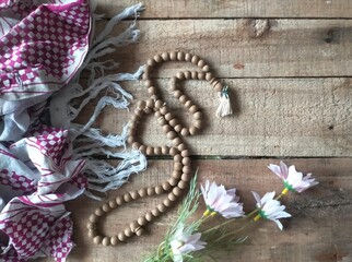 Scarf, prayer beads  and flowers on a table
