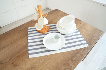 Set of different clean dishes on table in kitchen