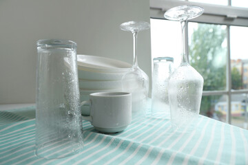 Set of clean dishes on table near window in kitchen