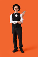 Obraz premium Young male bartender with shaker on orange background