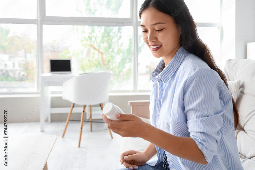 Poster young asian woman reading pills description at home