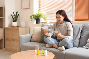 Young Asian woman checking pill description online at home