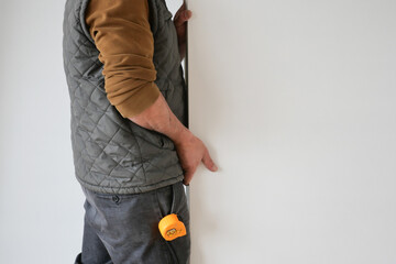 a man is measuring a wall with a tape measure