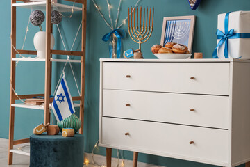 Chest of drawers and ottoman with traditional Hanukkah decorations in living room, closeup