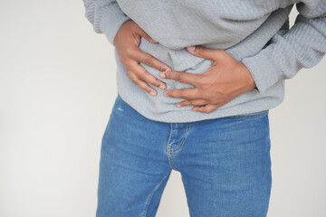 young man suffering stomach pain close up.