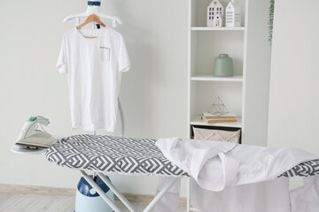 Interior of laundry room with garment steamer and ironing board