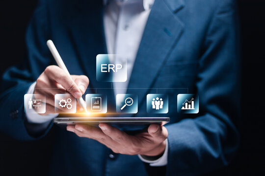 Enterprise Resource Planning concept. Connections between business intelligence, production, HR and CRM modules. Businessman use tablet to analyzing ERP system on virtual screen.