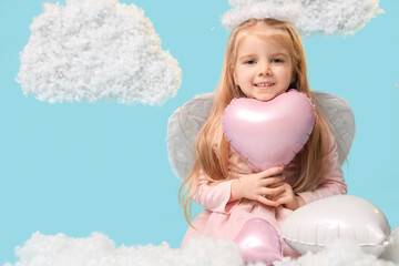 Cute little girl dressed as cupid with heart-shaped balloons and clouds on blue background....