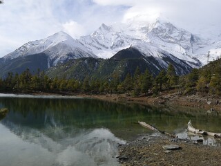 A majestic snowy mountain range towers over a pristine lake