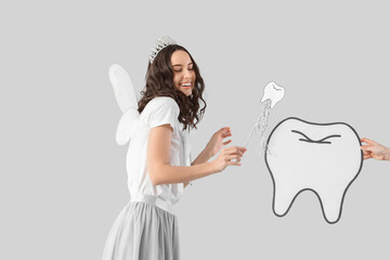 Tooth Fairy with wand and paper figure on light background