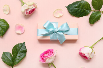 Gift box and beautiful roses on pink background. International Women's Day